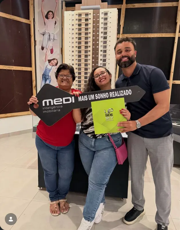 Mãe e filha segurando a chave simbólica após a assinatura